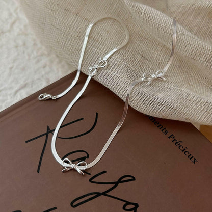 holding hengxin s925 sterling silk bow snake bone chain necklace women 2024 explosion niche senior smart light luxury clasia bone chain