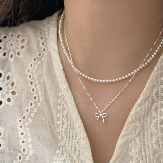 holding s925 sterling silver light luxury pearl bow dual layer stack wearing necklace female korean summer versatile clavicle chain